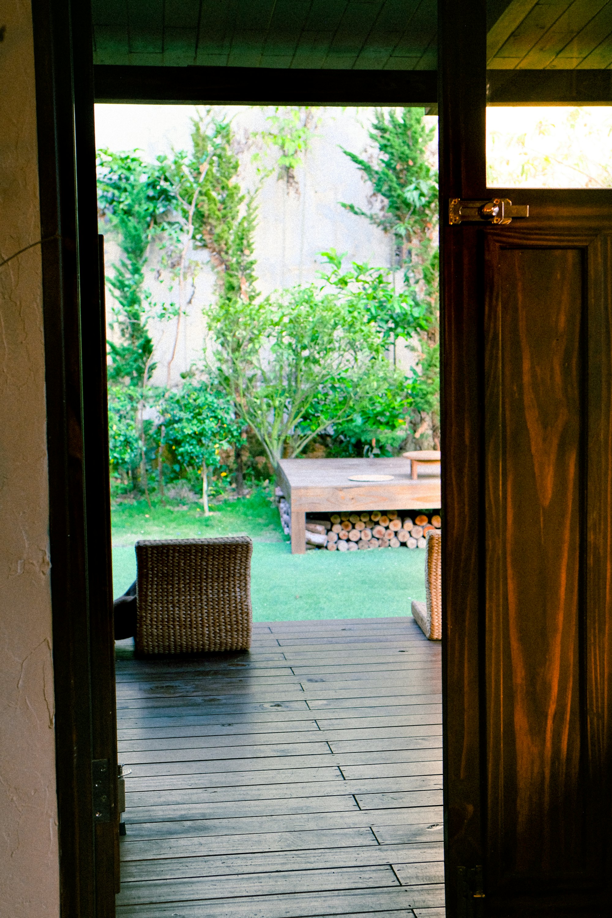 A timber doorway opening onto the planted deck and the forest beyond