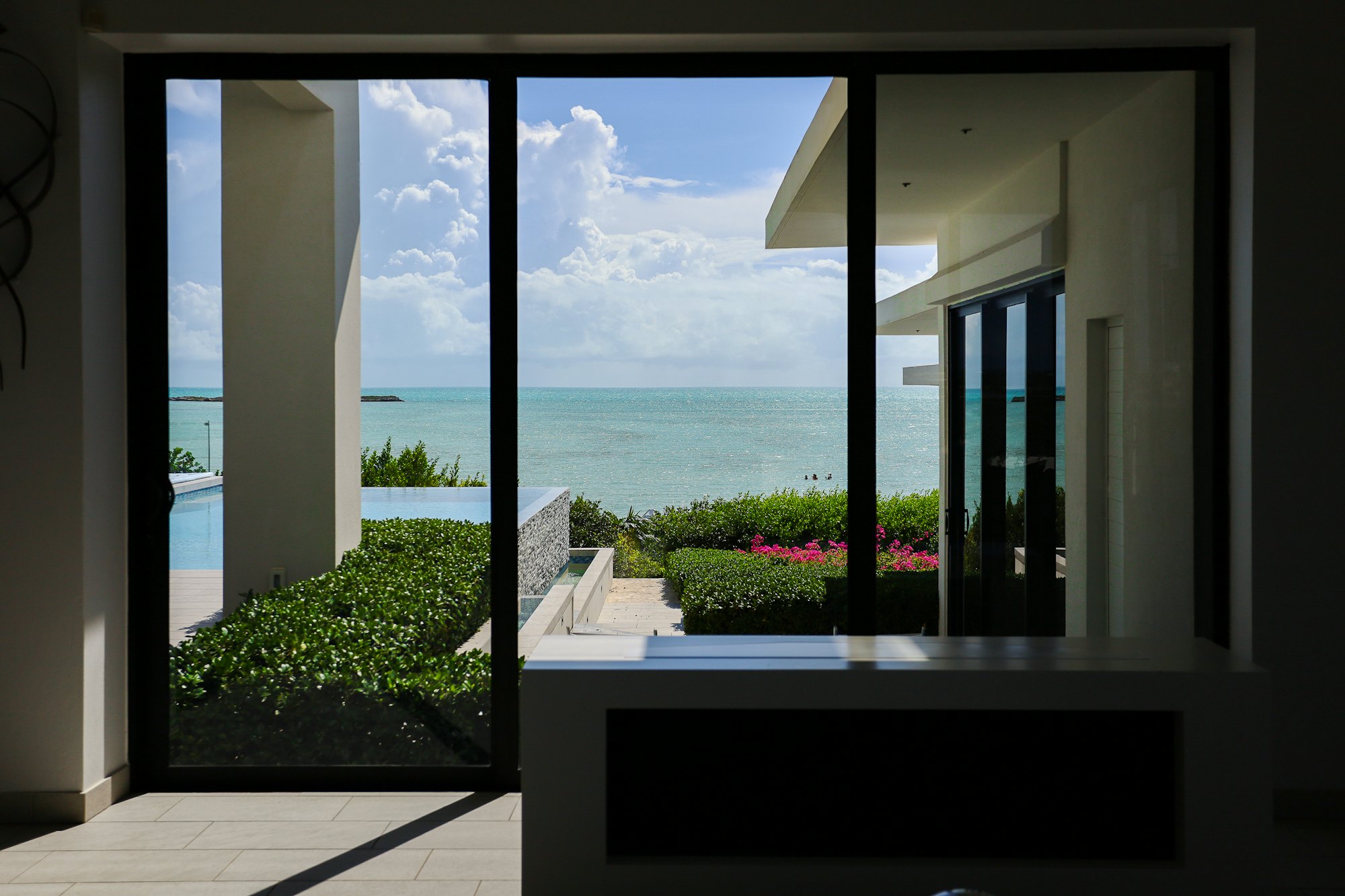 View over the infinity pool and ocean from the interior of Casa Luzia