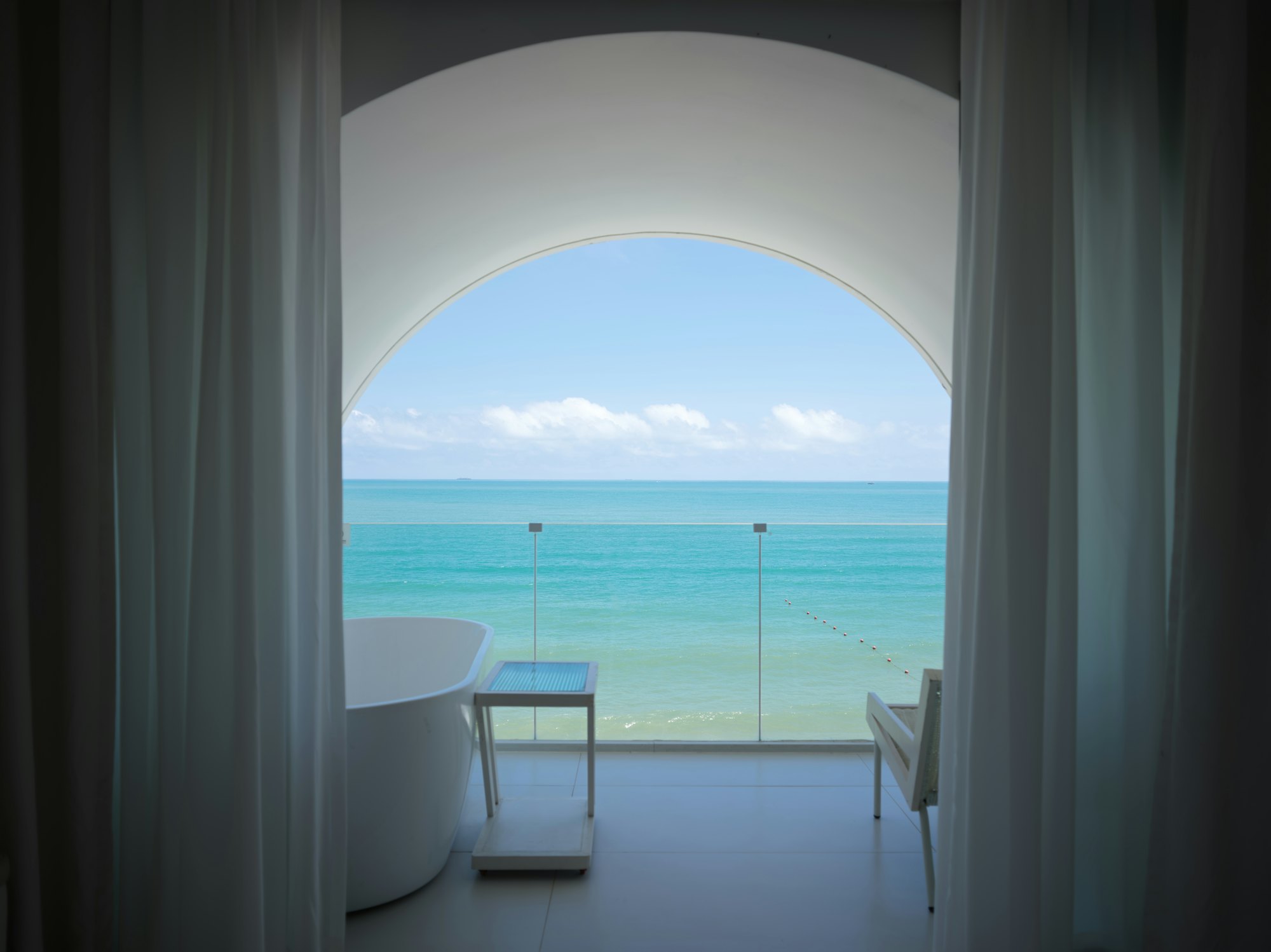 Arched opening framing the sea from a bedroom at Casa Luzia