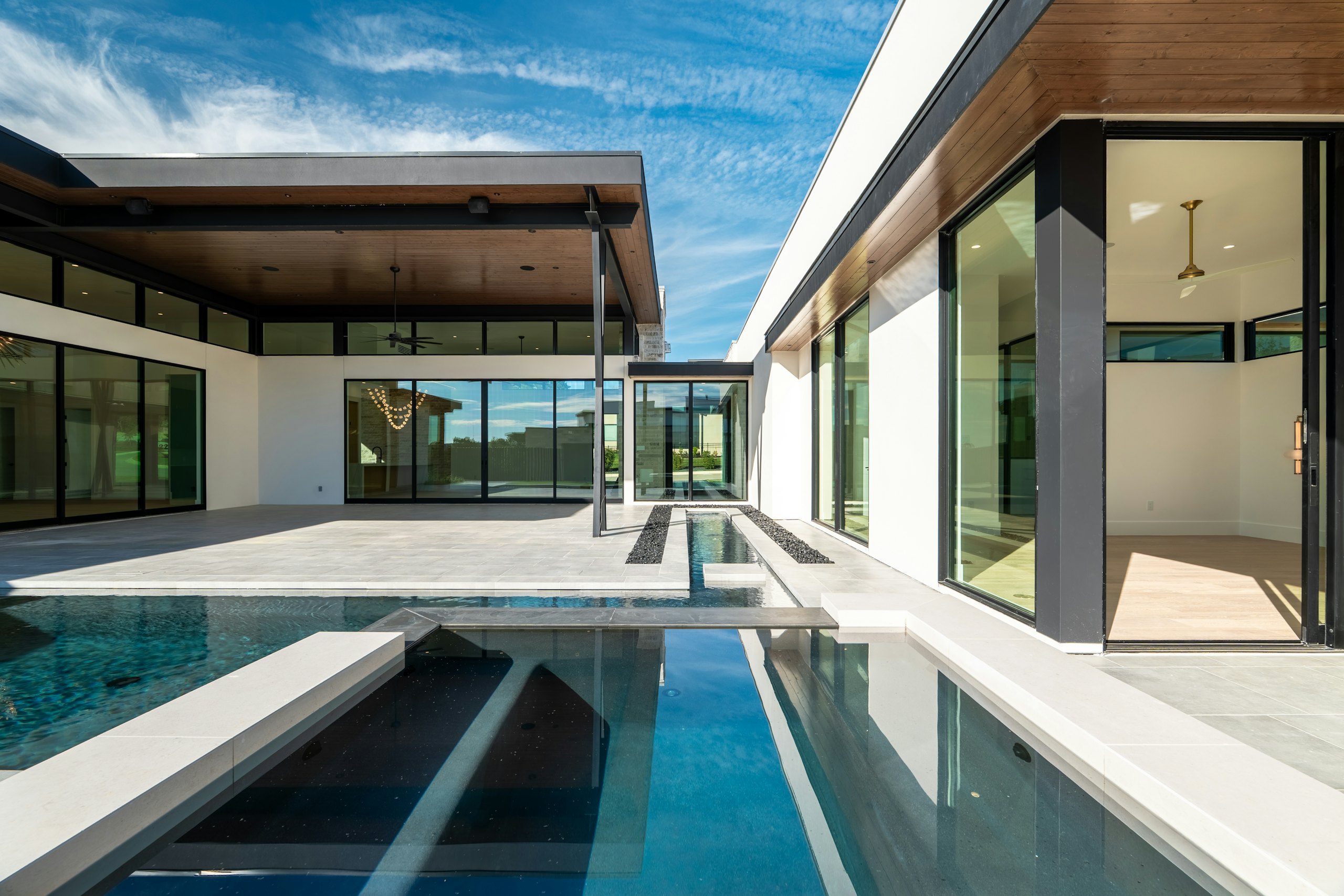 A modern house with a lap pool running towards the Pacific