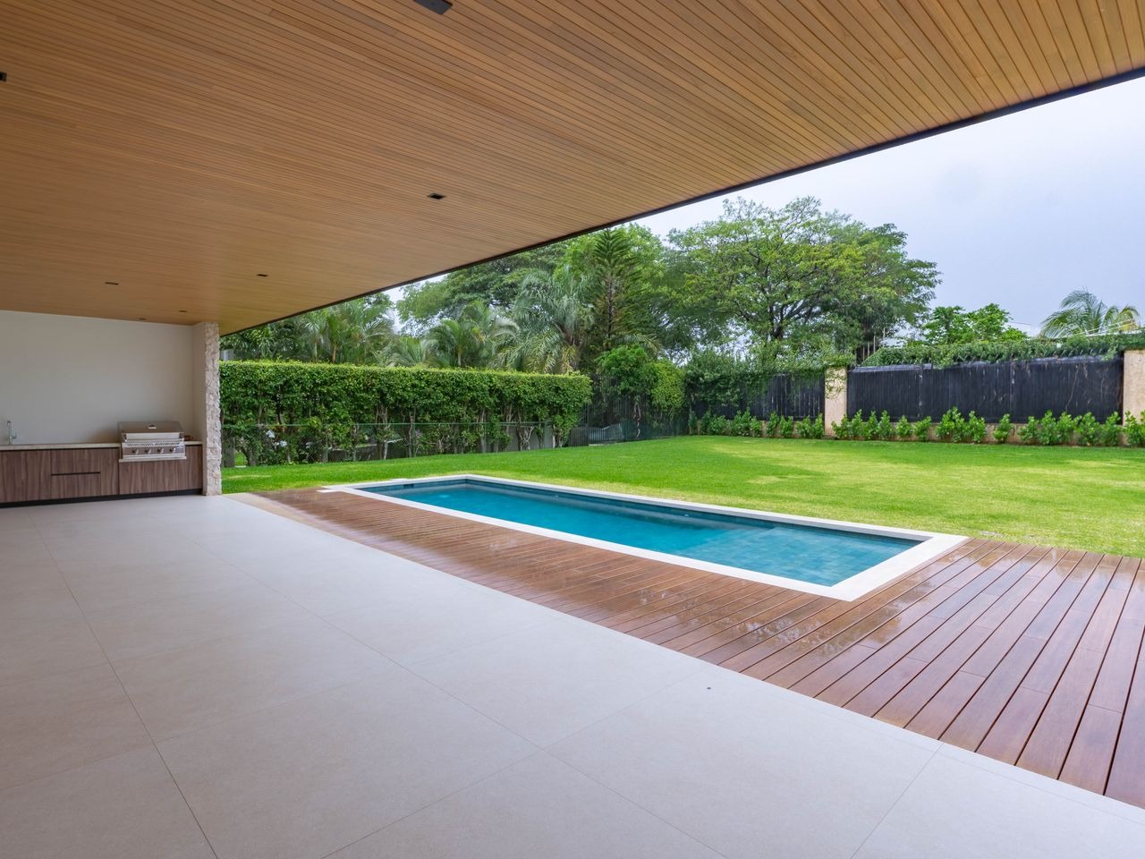 Covered terrace with a timber soffit looking over the pool and garden