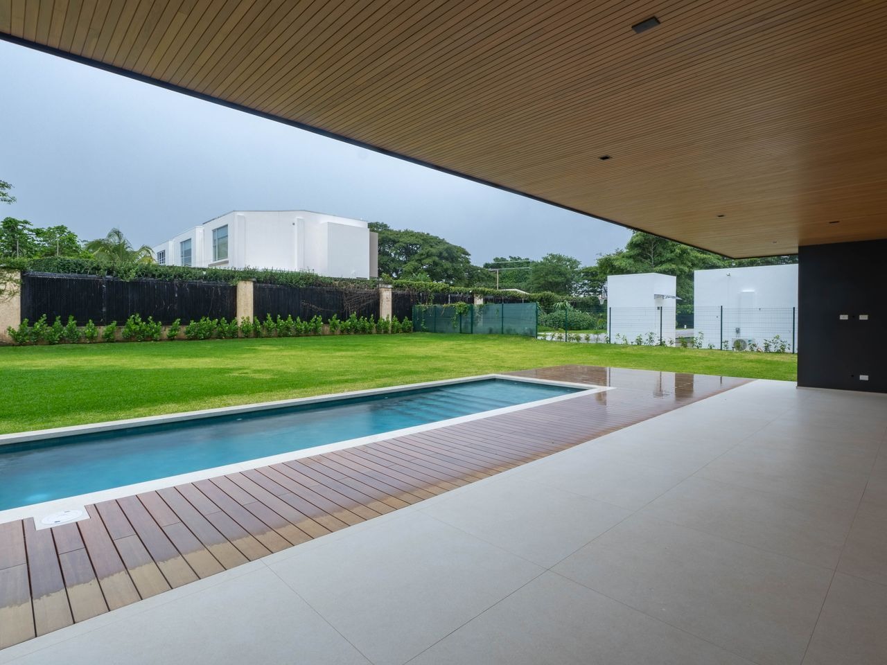 The pool running alongside the lawn, with the covered terrace to one side