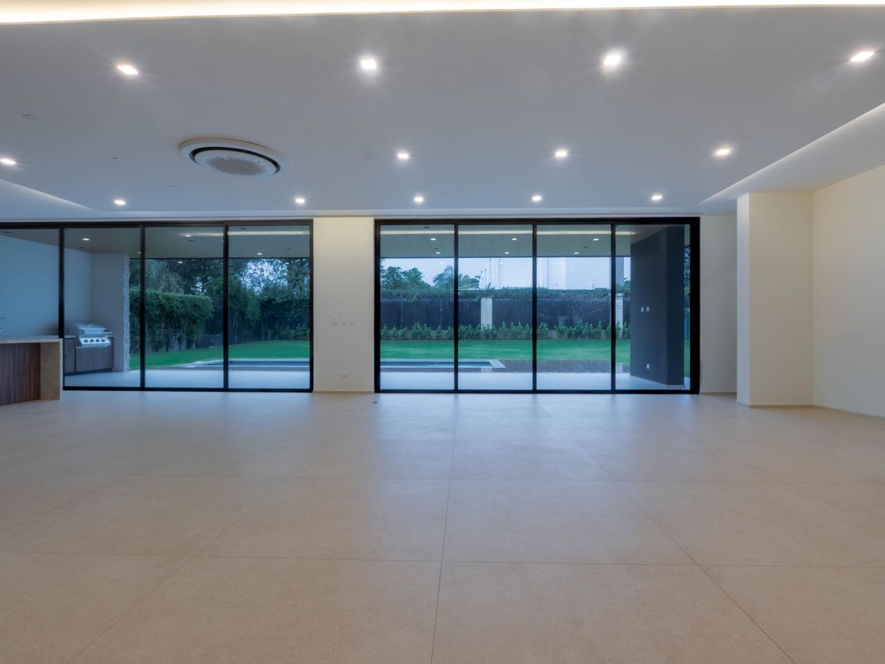 Living area opening to the garden through full-height sliding glazing