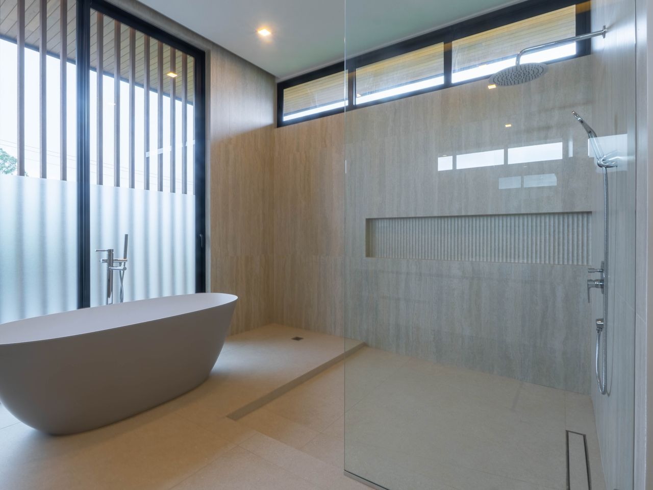 Primary bathroom with a freestanding tub beside the glazing